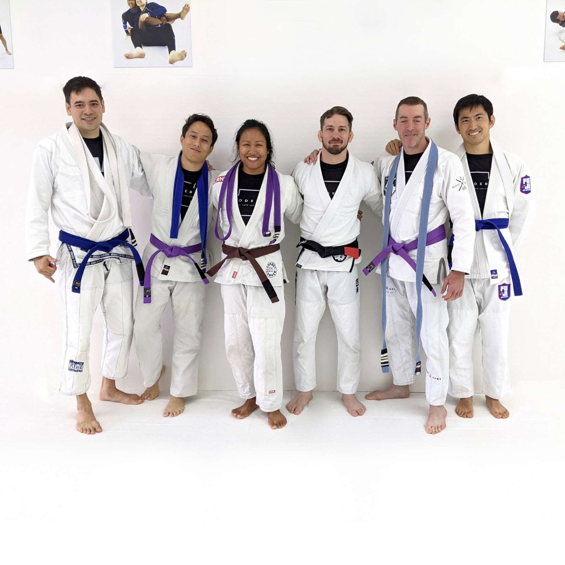 Photo of two students graduating to the rank of blue belt, two students graduating to the rank of purple belt, and Coach Savannah graduating to the rank of brown belt in Brazilian Jiu-Jitsu at Modern Martial Arts and Fitness in Pasadena, CA